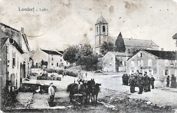 Postkarte der Ortschaft Landorf in Lothringen im Jahr 1917 mit Kirche, Häusern, und deutschen Soldaten.