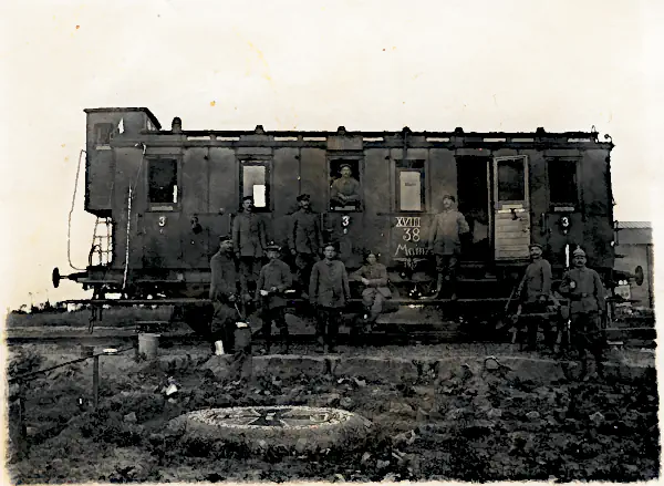 Historische Fotografie von Soldaten des XVIII. Armee-Korps (Mainz) vor einem Eisenbahnwagen im Ersten Weltkrieg.