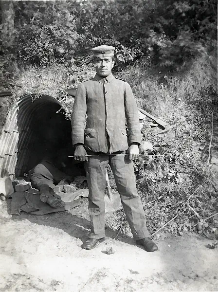 Historische Fotografie eines deutschen Soldaten vor einem wellblechgedeckten Unterstand im Ersten Weltkrieg